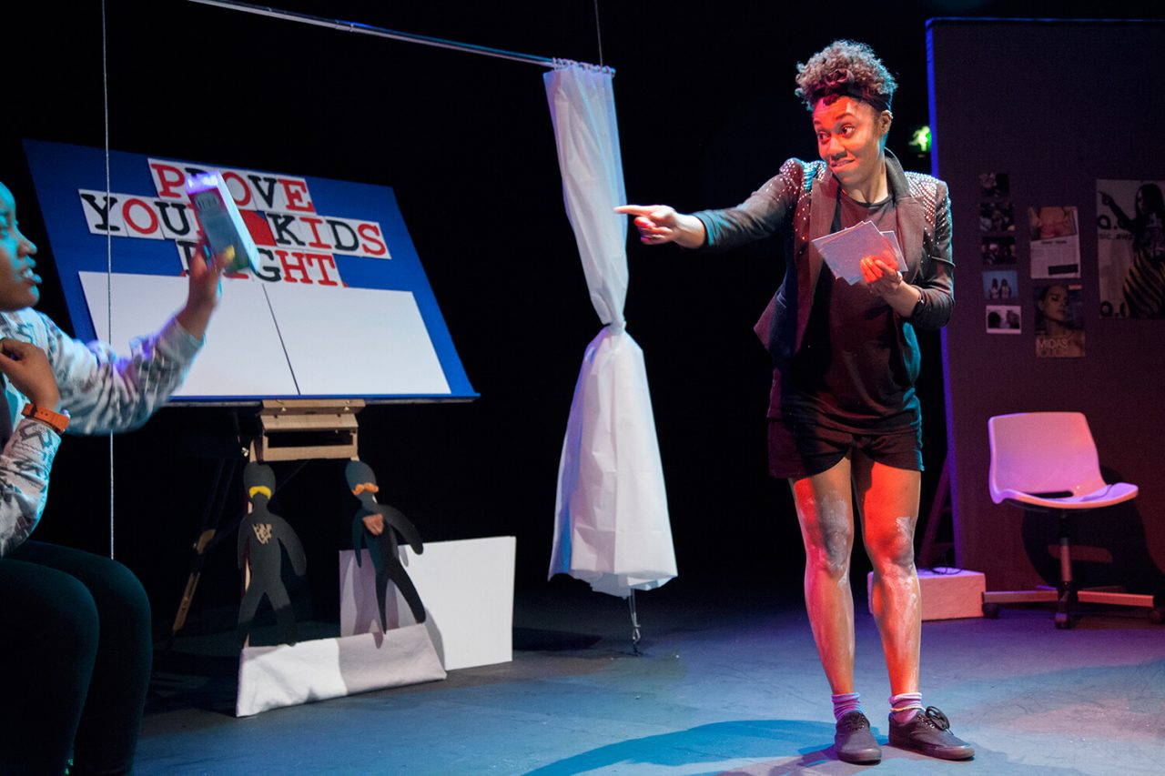 Keisha is wearing a blazer and is in front of a gameshow board. Image Credit - Zuza Photography