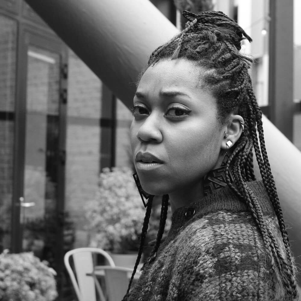Keisha is a brown skinned woman with braids in a top knot. She is looking defiantly at the camera. Image Credit - Elmi Ali